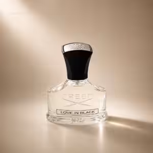 Creed Love in Black profumo donna, flacone trasparente con tappo nero in packshot luxury su sfondo dorato.
