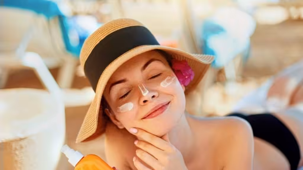 Donna che applica crema solare sul viso in una giornata soleggiata, simbolo di protezione SPF 50 contro i raggi UV