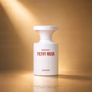 White perfume bottle labeled 'FILTHY MUSK' on a warm gold backdrop; elegant design with a wide top.