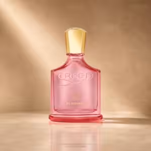 Creed Eladaria profumo donna, flacone rosa in packshot luxury su sfondo dorato.