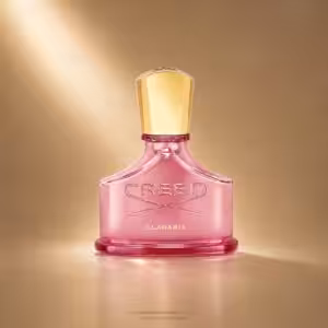 Pink Creed Eladaria perfume bottle with a tall gold cap against a warm gold background, embossed CREED on the bottle.