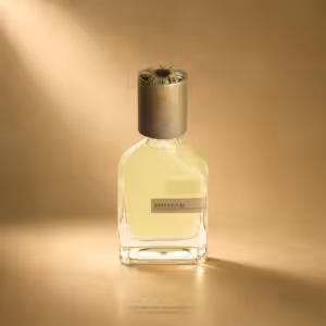 Perfume bottle with a heavy dark cap and pale yellow liquid, label reads RISVELIUM, against a warm, soft-lit background.