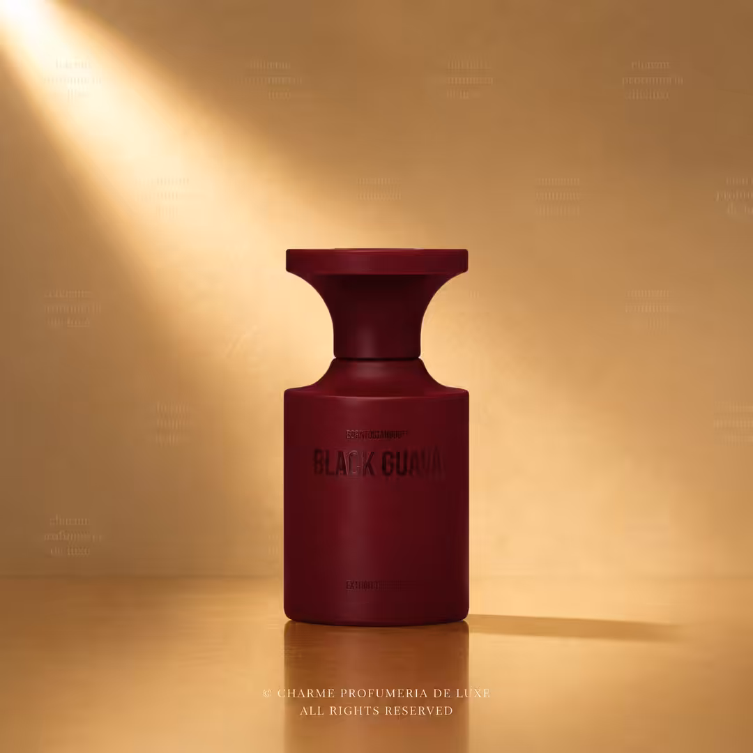 Maroon perfume bottle labeled Black Guava on a warm, amber backdrop with soft spotlight.