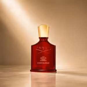 Creed Centaurus profumo unisex, flacone rosso in packshot luxury su sfondo dorato.