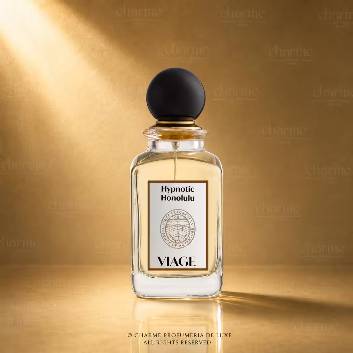 Viage Hypnotic Honolulu Extrait de Parfum 100 ml, flacone in vetro trasparente con liquido ambrato su sfondo dorato Charme Profumeria de Luxe