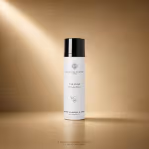 White cylindrical perfume bottle with black cap labeled Essential Parfums Paris, The Musc by Calice Becker, on a warm gold backdrop.
