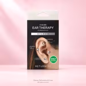 RETURNITY Ear Therapy Acupressure Patch Silver, confezione nera di patch auricolari decorativi su sfondo rosa.